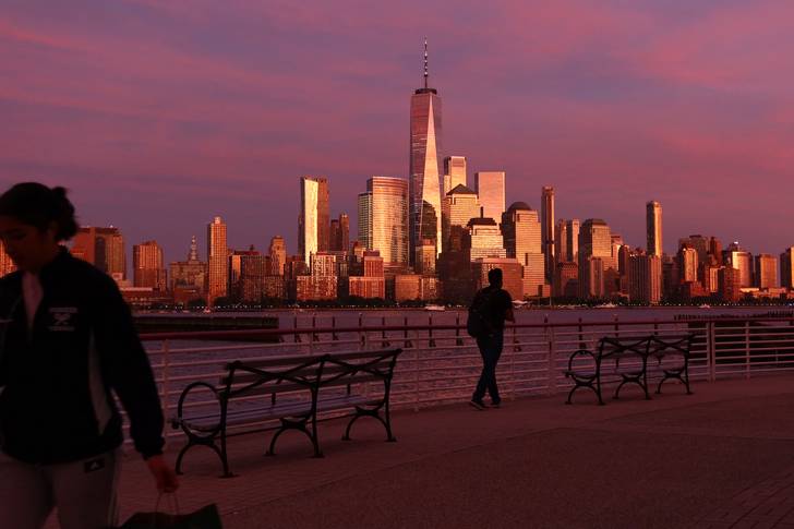 The sky turned pink and the buildings in lower Manhattan gold as the sun set in New York City on September 29, 2022, as seen from Jersey City, New Jersey. (